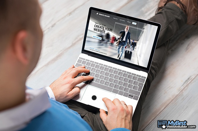 Squarespace alternatives: a man holding a laptop with a website builder on the screen.