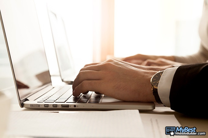 Best email hosting: a man typing on a laptop.