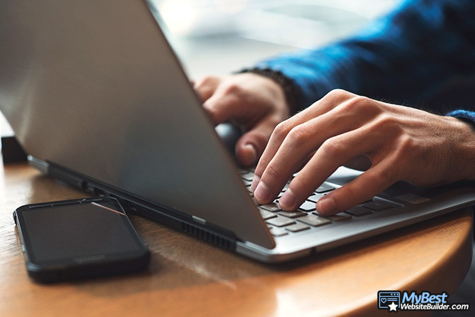 GoDaddy alternatives: a close shot of man's hands typing on a laptop.