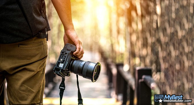 Melhores criadores de sites para fotógrafos: fotógrafo segurando uma câmera.