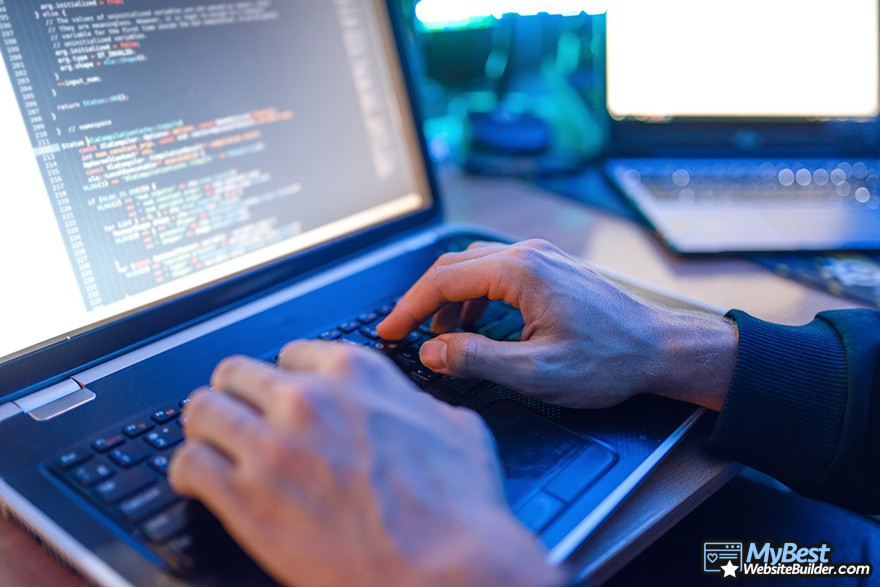 Wix VS GoDaddy: a man programming on a laptop.